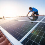 Professional worker installing solar panels on the roof of a house. stock photo